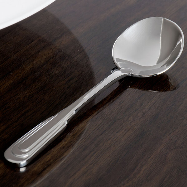A Oneida Cityscape stainless steel spoon with a silver handle on a table.