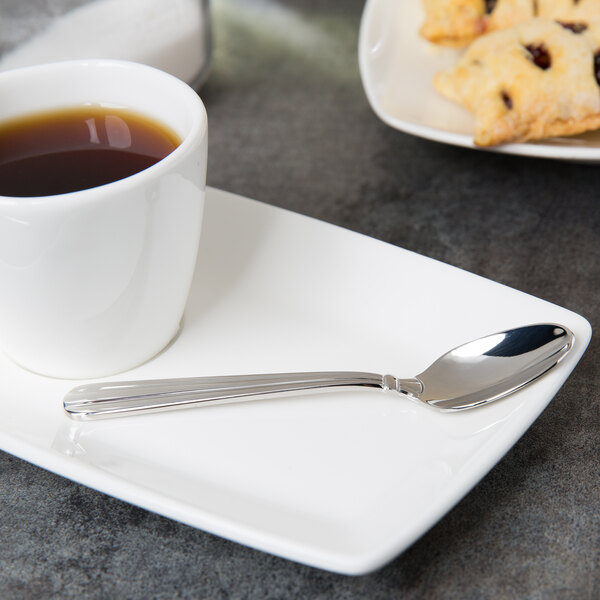A cup of coffee with a Oneida Unity stainless steel demitasse spoon on a plate.