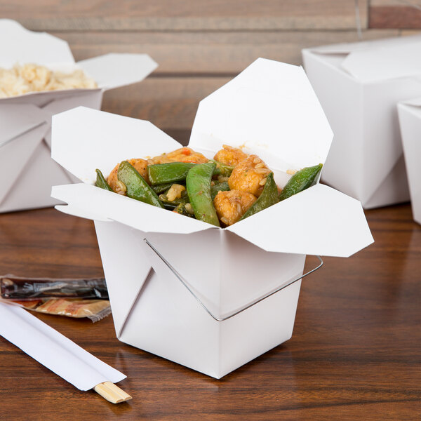 A white Fold-Pak Chinese take-out box on a table with food and chopsticks.