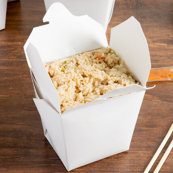 A white Fold-Pak take-out container filled with food on a table.
