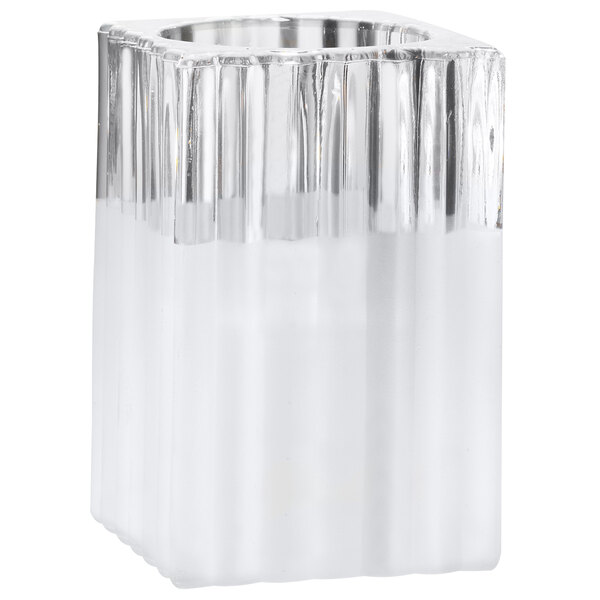 A Sterno ribbed frost glass square candle holder with white liquid inside.