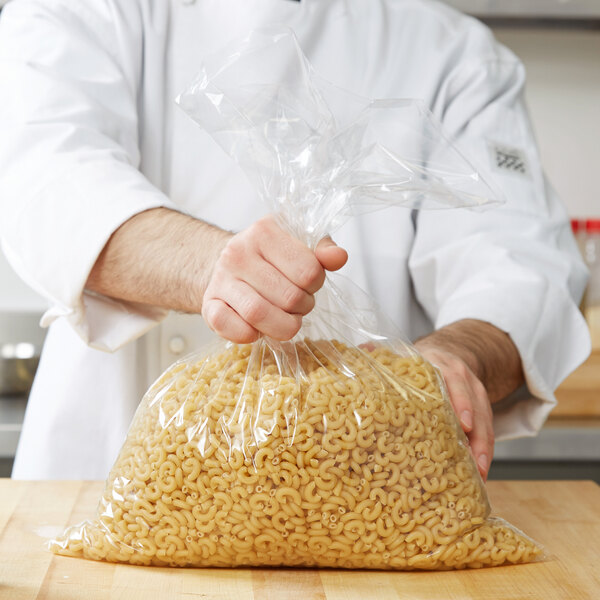 A man holding a LK Packaging plastic food bag of pasta.