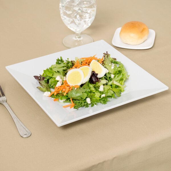 A white Siciliano square melamine plate with a salad, hard boiled eggs, and a fork.