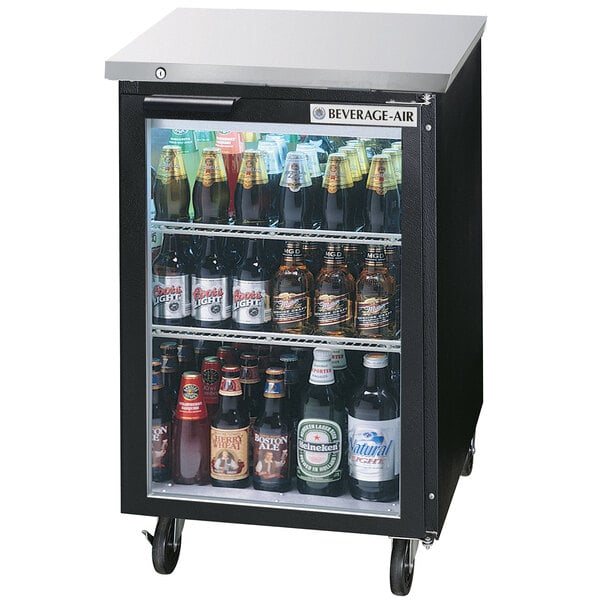 A Beverage-Air black back bar refrigerator with shelves full of beer bottles.