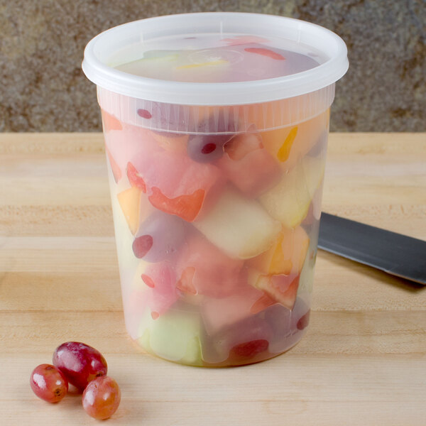 A Pactiv plastic container filled with fruit salad on a counter.
