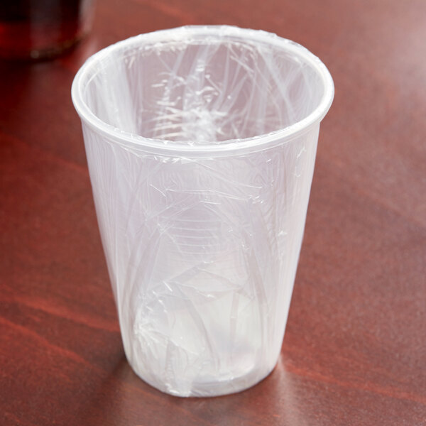 A Lavex translucent plastic cup individually wrapped in plastic on a table.