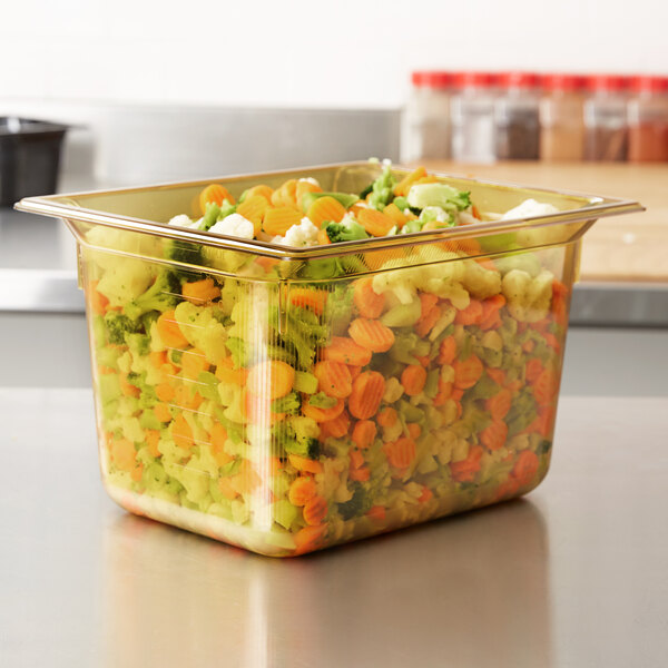 A Vollrath amber plastic food pan filled with vegetables.
