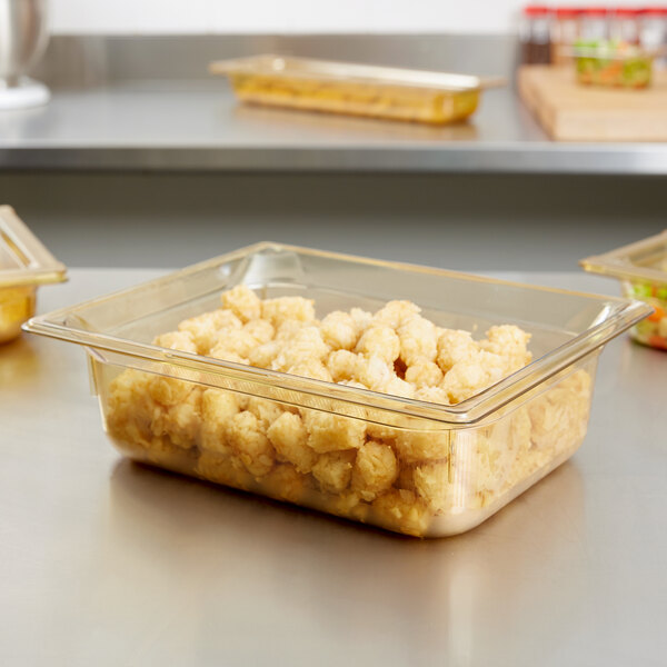 A clear Vollrath plastic food pan filled with food on a counter.