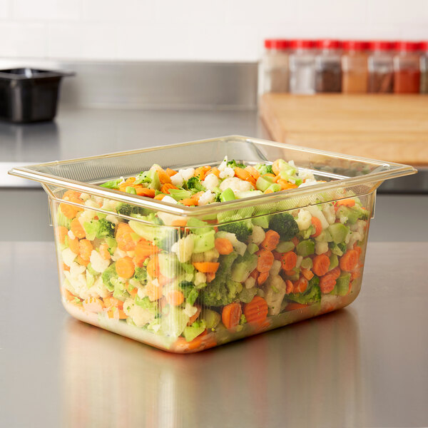 A Vollrath amber plastic food pan with vegetables in it.