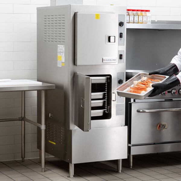 A chef using a Cleveland SteamCraft Ultra steamer in a professional kitchen.
