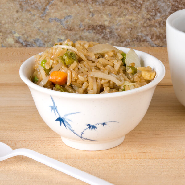 A blue Thunder Group Blue Bamboo melamine rice bowl filled with rice and vegetables on a wooden surface.