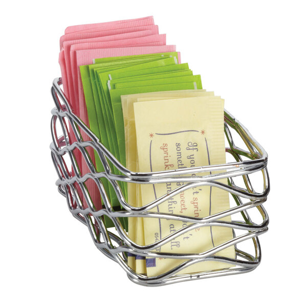 A chrome wire basket with a stack of sugar packets inside.