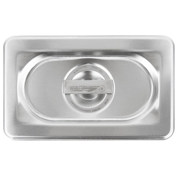 A Vollrath stainless steel long rectangular lid with a circular handle on top of a metal container.