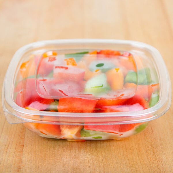 A clear Sabert plastic container filled with food.