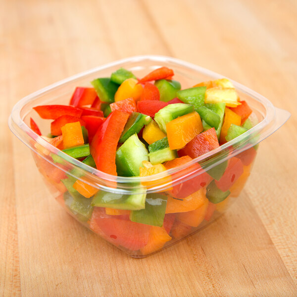 A Sabert clear plastic bowl filled with chopped bell peppers.