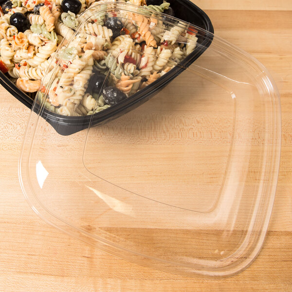 A clear plastic flat lid on a plastic container of food.