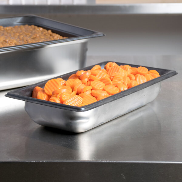 A Vollrath stainless steel steam table pan with food on a counter.