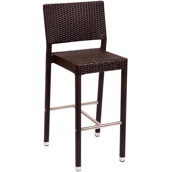 A BFM Seating Monterey wicker bar height chair with a metal frame.