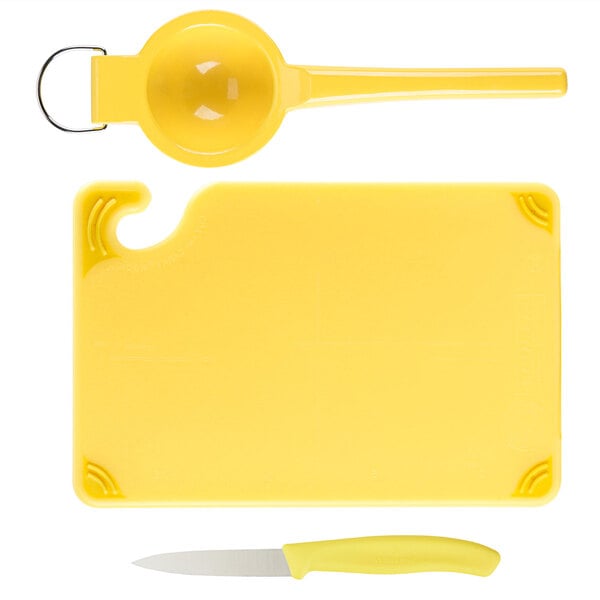 A yellow Saf-T-Grip plastic cutting board with a knife and spoon.