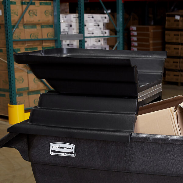 A black bin with a stack of boxes in it.