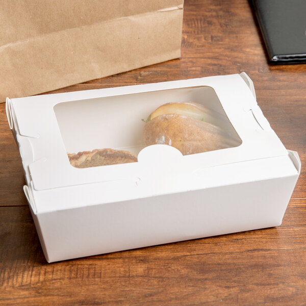 A white Bio-Pak take-out box with food inside.