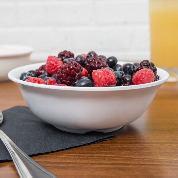 A white GET SuperMel bowl filled with berries on a table.
