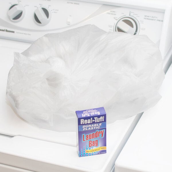 A case of white Real Tuff plastic laundry bags on top of a washing machine.