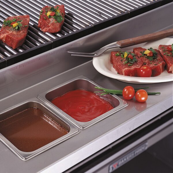 A Bakers Pride stainless steel work deck with meat on a grill.