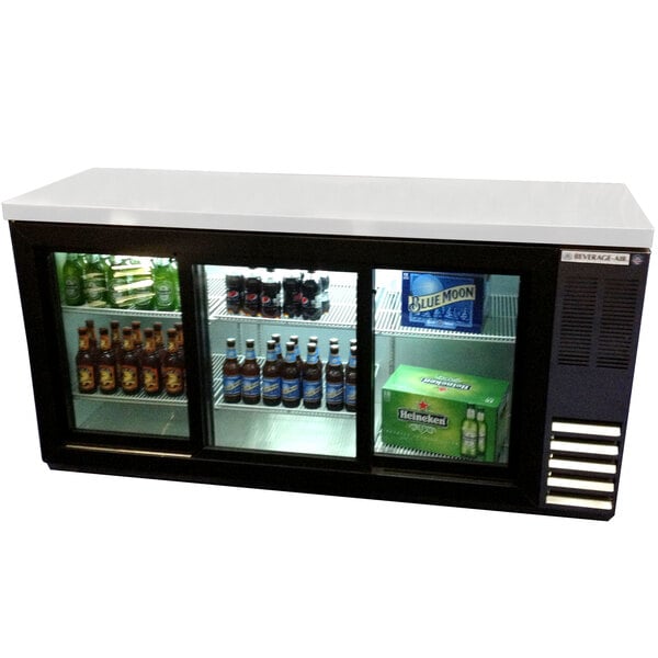 A Beverage-Air black back bar refrigerator with sliding glass doors and bottles of beer on shelves.