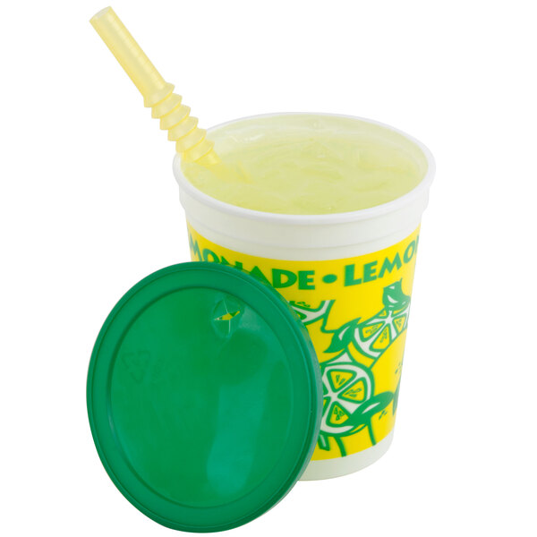 A yellow and white 16 oz. plastic lemonade cup with a green lid and straw.