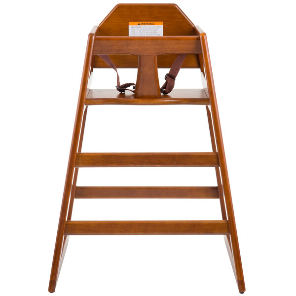 A Tablecraft wooden high chair with a walnut finish and strap.