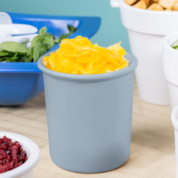 A gray Tablecraft cast aluminum condiment bowl filled with yellow food on a white surface.
