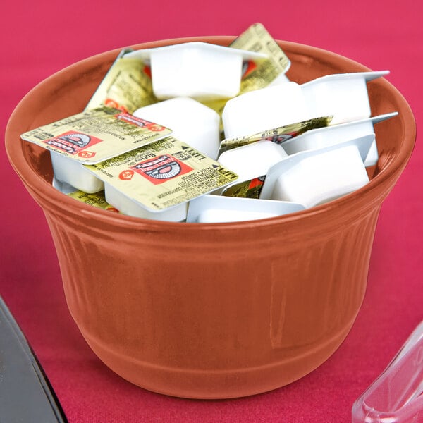 A Tablecraft copper cast aluminum bowl filled with tea bags and sugar on a hotel buffet table.