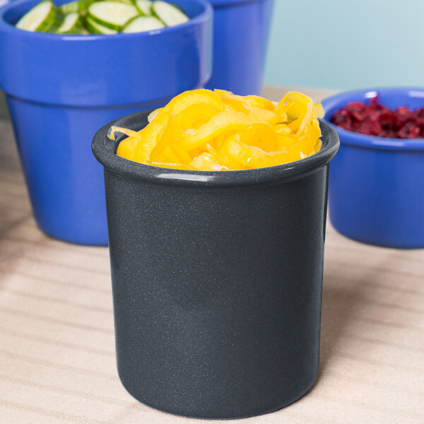 A blue Tablecraft cast aluminum bowl with yellow food inside on a counter.