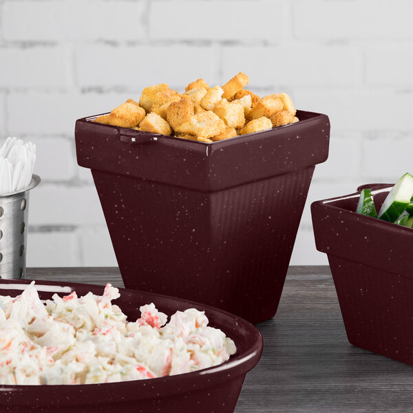 A maroon Tablecraft square condiment bowl filled with food on a table in a salad bar.