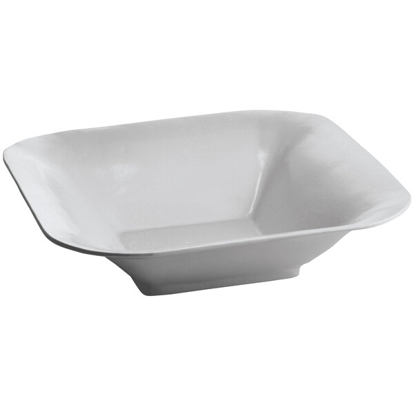 A gray square cast aluminum bowl with a handle.