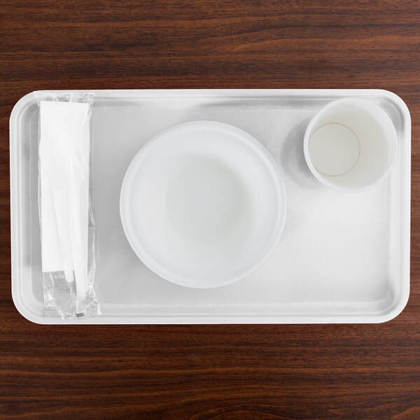 A white rectangular Cambro tray with a white bowl and cup on it.