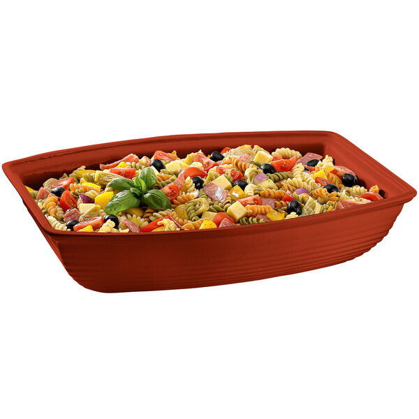 A red rectangular Tablecraft copper cast aluminum bowl with pasta salad in it.