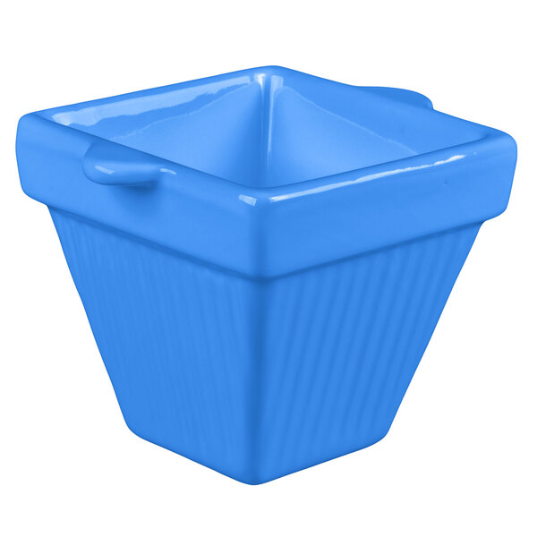 A cobalt blue square cast aluminum bowl with a handle.