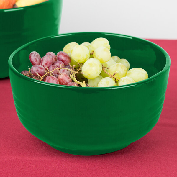 A Tablecraft green cast aluminum fruit bowl filled with grapes.
