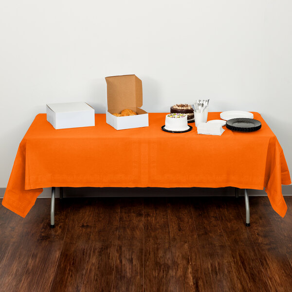A Sunkissed Orange table cover on a table with food.