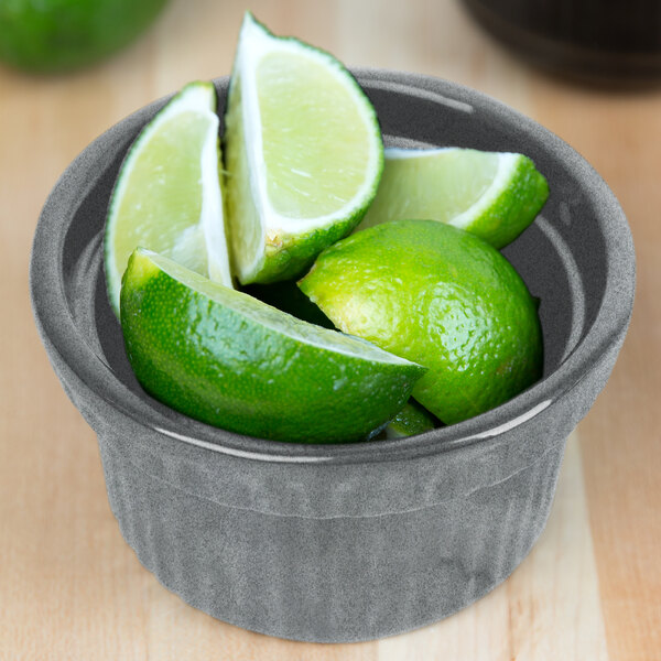 A Tablecraft granite cast aluminum souffle bowl filled with lime wedges.