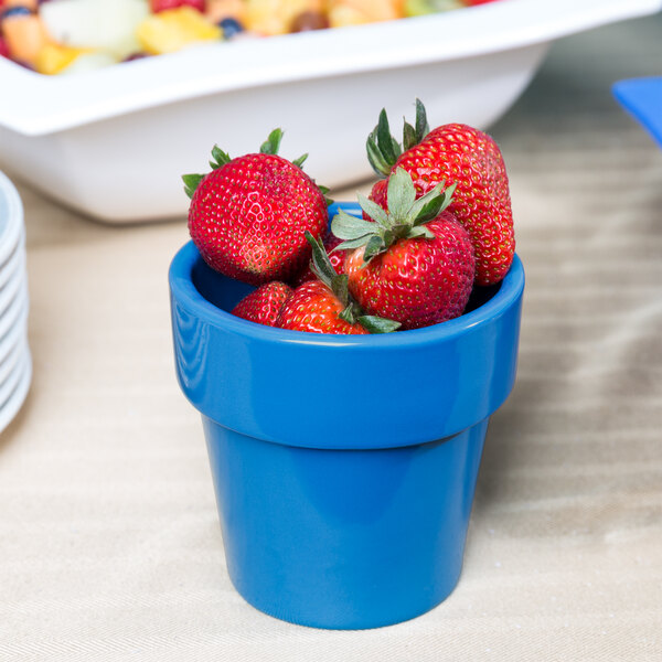 A Sky Blue Tablecraft condiment bowl filled with strawberries.
