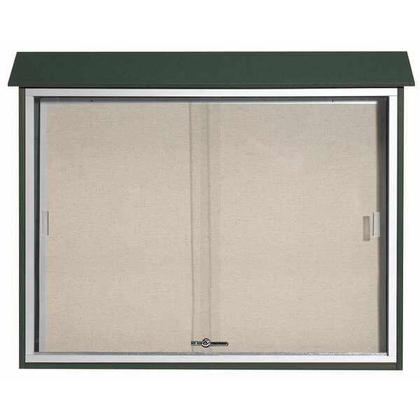 A green rectangular message center with a vinyl tackboard and sliding glass door.