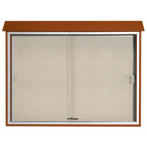 A brown rectangular cabinet with sliding white doors over a white vinyl tackboard.