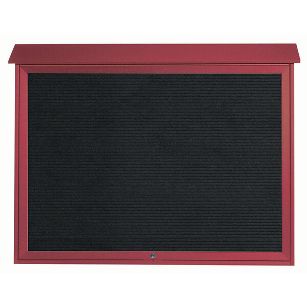 A black board with a red frame on a red surface.