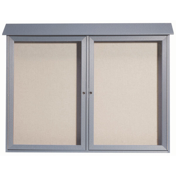 A grey rectangular Aarco message center with two doors.