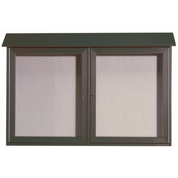 A green outdoor Aarco message center with vinyl tackboard and dual hinged doors.