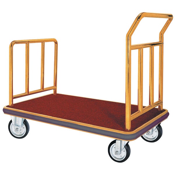 A stainless steel luggage cart with brass metal rails and a red carpet on it.