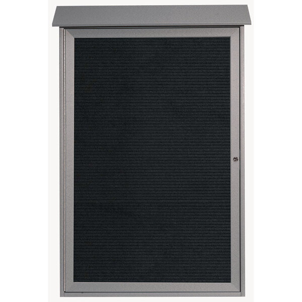 A light grey Aarco outdoor message center with a black board and a black enclosed door.